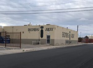Tan building with "Bombs Away" and a picture of a bomb stenciled on the sides.